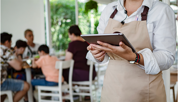 Waitress holding tablet serving customers